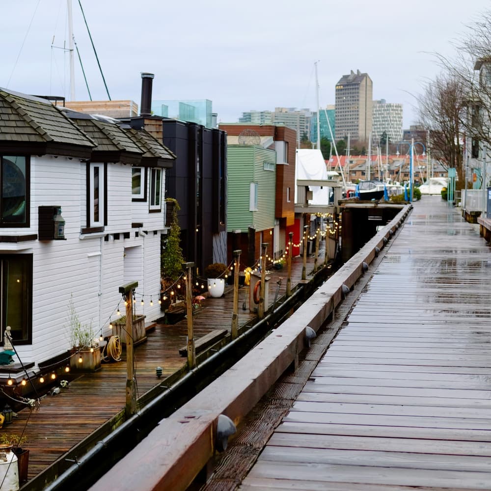 Float homes along a wooden dock on a rainy day